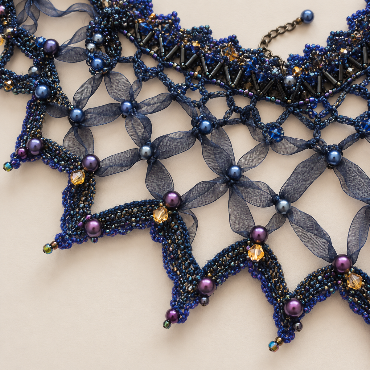 Close-up of blue and purple beads and gold crystals on handmade capelet
