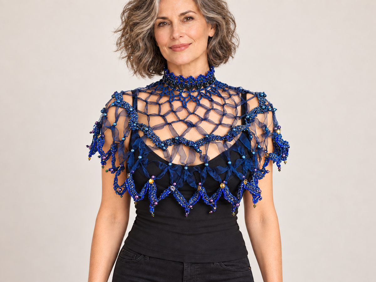 Dark blue handmade web capelet worn by a woman – front view