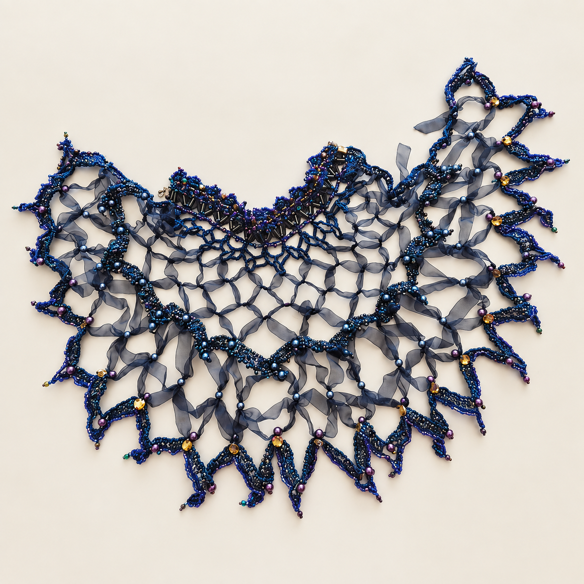 Dark blue handmade web capelet with beadwork laid flat