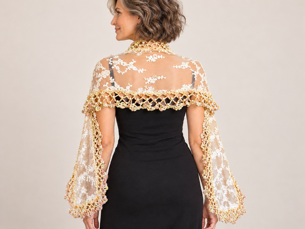 Long ecru lace shawl with pearl crochet edging worn over a black dress – back view