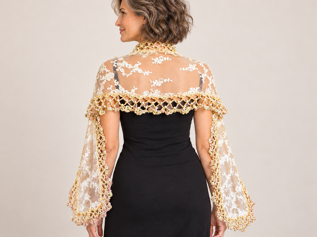 Long ecru lace shawl with pearl crochet edging worn over a black dress – back view