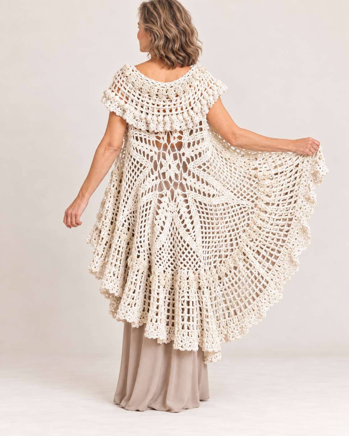 Cream crochet circular cape vest worn by a blonde woman – back view